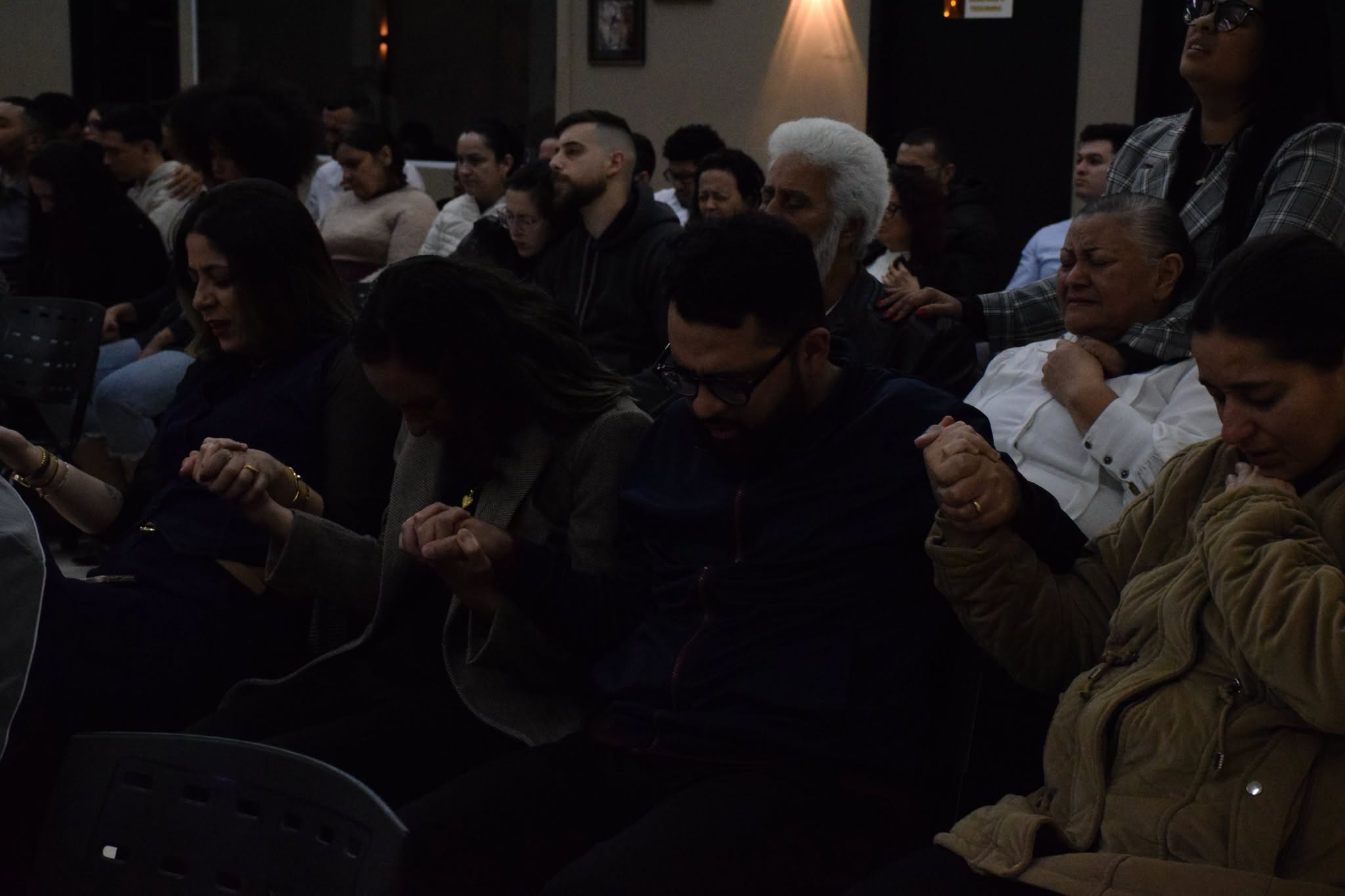 Irmãos reunidos em comunhão e oração durante o culto